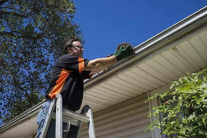 a worker using tools to fix a broken gutter in Hazleton